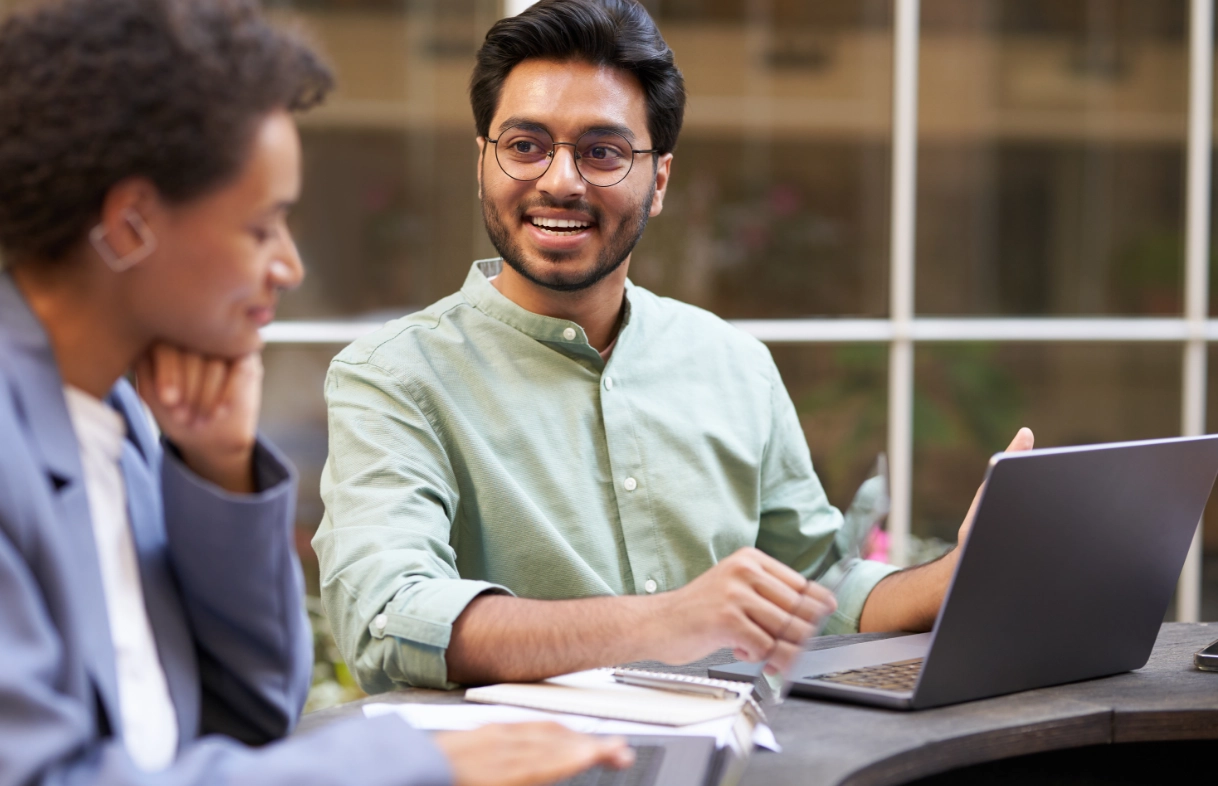a man in glasses looking at a laptop